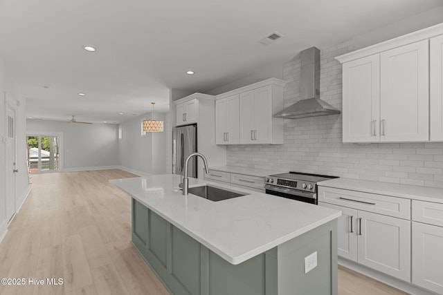 207 Spartanburg Ave Unit 1 & 2, Carolina Beach, NC 28428 - kitchen with wall chimney exhaust hood, stainless steel appliances, backsplash, white cabinets, and recessed lighting