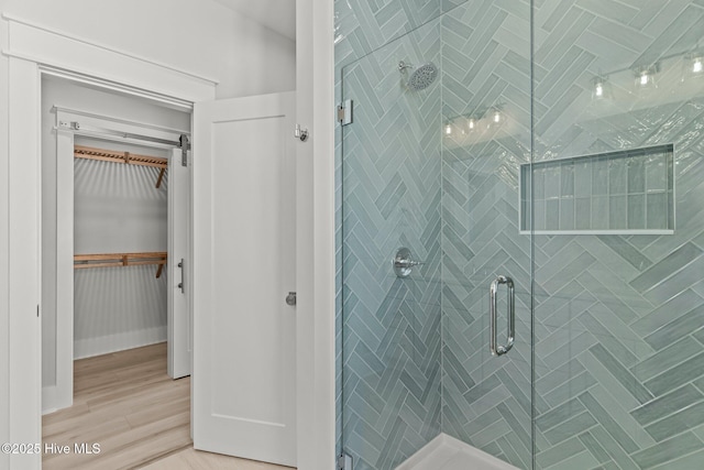 207 Spartanburg Ave Unit 1 & 2, Carolina Beach, NC 28428 - full bathroom with a stall shower, a walk in closet, and wood finished floors
