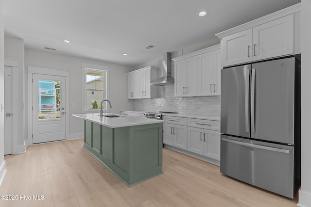 207 Spartanburg Ave Unit 1 & 2, Carolina Beach, NC 28428 - kitchen with appliances with stainless steel finishes, wall chimney exhaust hood, light countertops, light wood-style flooring, and recessed lighting