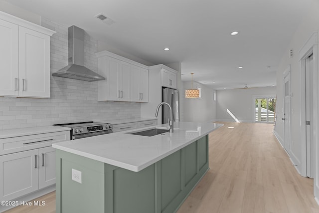 207 Spartanburg Ave Unit 1 & 2, Carolina Beach, NC 28428 - kitchen with wall chimney range hood, appliances with stainless steel finishes, a kitchen island with sink, white cabinetry, and recessed lighting