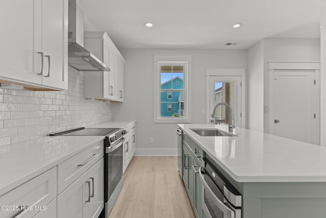 207 Spartanburg Ave Unit 1 & 2, Carolina Beach, NC 28428 - kitchen featuring wall chimney exhaust hood, stainless steel electric range oven, light wood-style flooring, white cabinetry, and tasteful backsplash