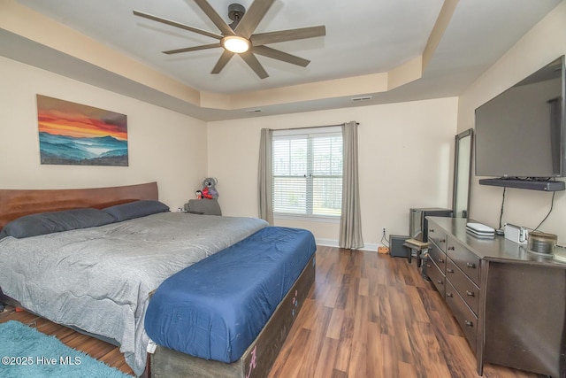 1247 Dunlop Dr NE, Leland, NC 28451 - bedroom featuring dark wood finished floors, a tray ceiling, and a ceiling fan