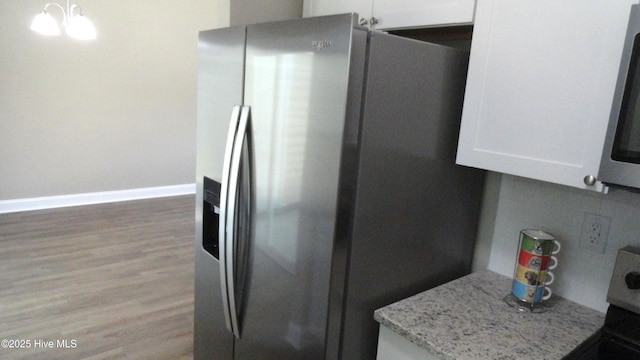 109 Lewis Ct, Havelock, NC 28532 - kitchen with stainless steel fridge with ice dispenser, white cabinets, light wood finished floors, light stone counters, and range