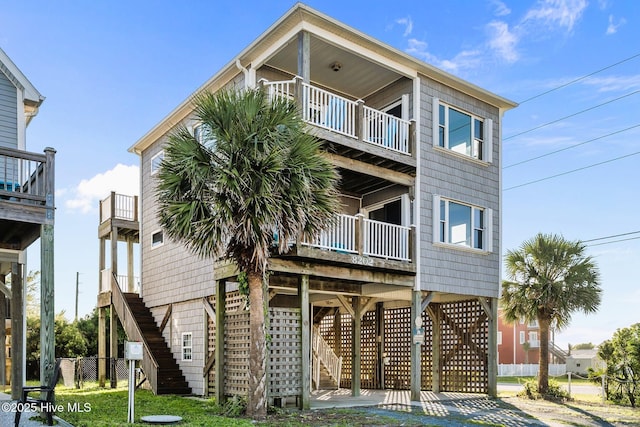 8202 5th Ave, North Topsail Beach, NC 28460 - back of house with a balcony, stairs, and a carport