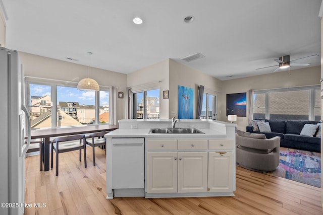 8202 5th Ave, North Topsail Beach, NC 28460 - kitchen with white appliances, open floor plan, white cabinets, light wood-type flooring, and recessed lighting