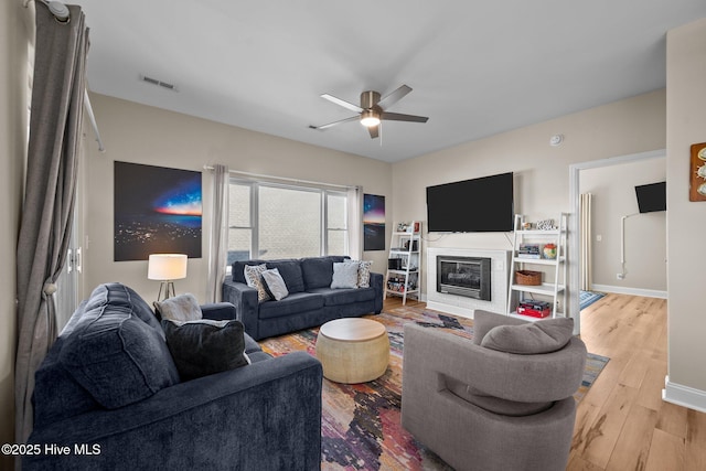 8202 5th Ave, North Topsail Beach, NC 28460 - living room with wood finished floors, a ceiling fan, and a glass covered fireplace