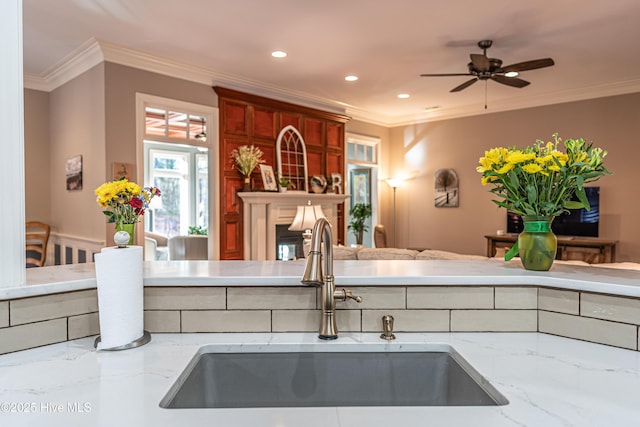 56 Kilbride Dr, Pinehurst, NC 28374 - kitchen featuring crown molding, a fireplace, light stone counters, recessed lighting, and a ceiling fan
