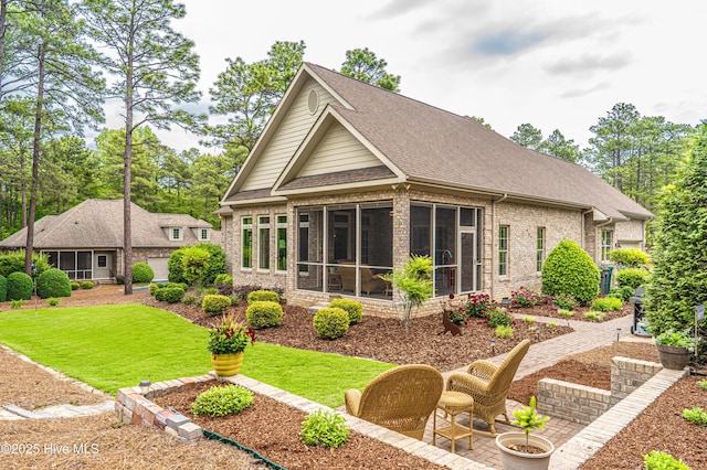 56 Kilbride Dr, Pinehurst, NC 28374 - rear view of house featuring brick siding, a sunroom, a shingled roof, and a yard
