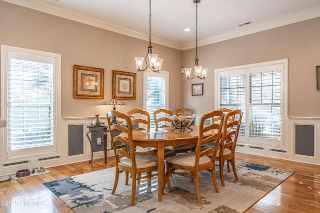 56 Kilbride Dr, Pinehurst, NC 28374 - dining room featuring a chandelier, plenty of natural light, ornamental molding, a wainscoted wall, and light wood-type flooring