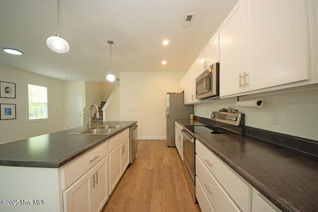 146 Poplar St, Jacksonville, NC 28540 - kitchen featuring stainless steel appliances, dark countertops, white cabinets, light wood-type flooring, and pendant lighting