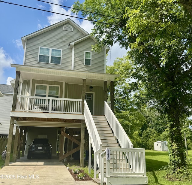146 Poplar St, Jacksonville, NC 28540 - coastal home with a carport, covered porch, concrete driveway, board and batten siding, and stairway