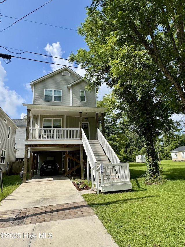 146 Poplar St, Jacksonville, NC 28540 - coastal home with a carport, a porch, driveway, and a front lawn