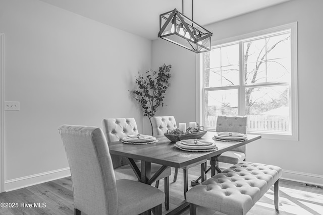 1165 Burning Tree Rd, Pinehurst, NC 28374 - dining room with plenty of natural light, a chandelier, and wood finished floors