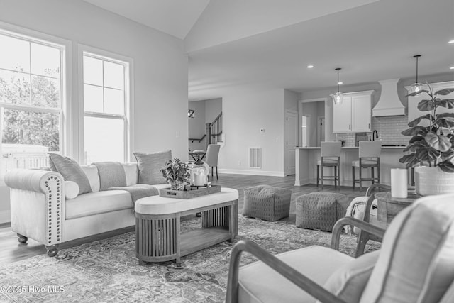 1165 Burning Tree Rd, Pinehurst, NC 28374 - living room featuring vaulted ceiling, wood finished floors, stairs, and recessed lighting