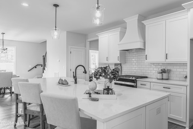 1165 Burning Tree Rd, Pinehurst, NC 28374 - kitchen with premium range hood, electric stove, a kitchen island with sink, white cabinetry, and decorative backsplash