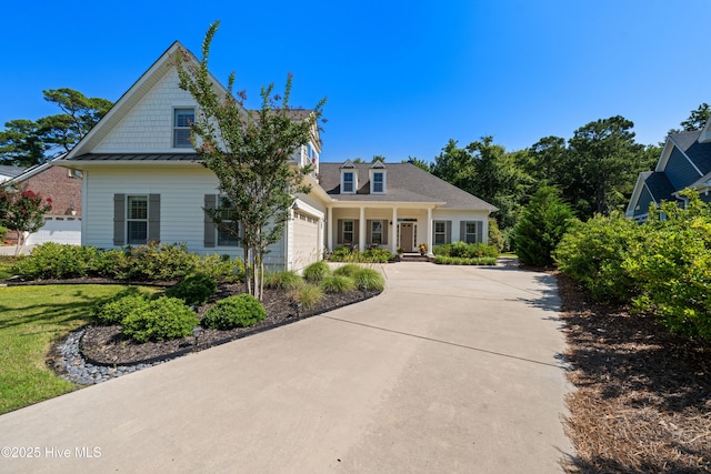 2675 Four Oak Rd, Southport, NC 28461 - view of front of home with driveway, a standing seam roof, covered porch, and a garage
