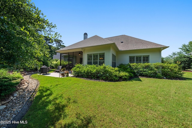 2675 Four Oak Rd, Southport, NC 28461 - rear view of house featuring a chimney, a patio area, a lawn, and ceiling fan