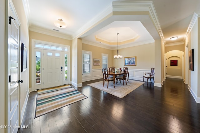 2675 Four Oak Rd, Southport, NC 28461 - entryway with dark wood-type flooring, arched walkways, a chandelier, and ornamental molding