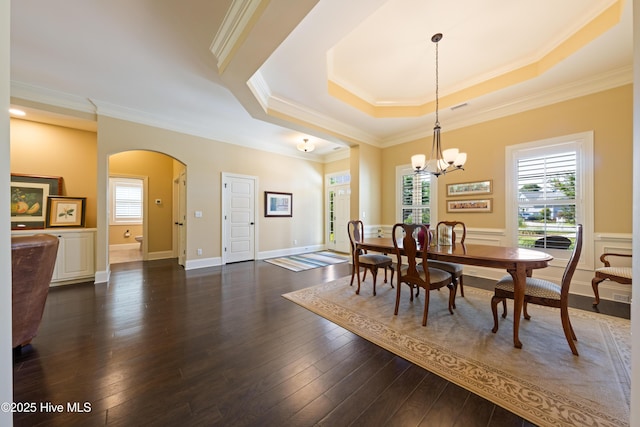 2675 Four Oak Rd, Southport, NC 28461 - dining space featuring arched walkways, crown molding, healthy amount of natural light, a chandelier, and dark wood-style floors