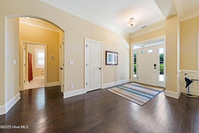 2675 Four Oak Rd, Southport, NC 28461 - entrance foyer with arched walkways, ornamental molding, and dark wood-type flooring