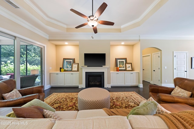 2675 Four Oak Rd, Southport, NC 28461 - living area featuring arched walkways, ceiling fan, a raised ceiling, ornamental molding, and dark wood-style floors