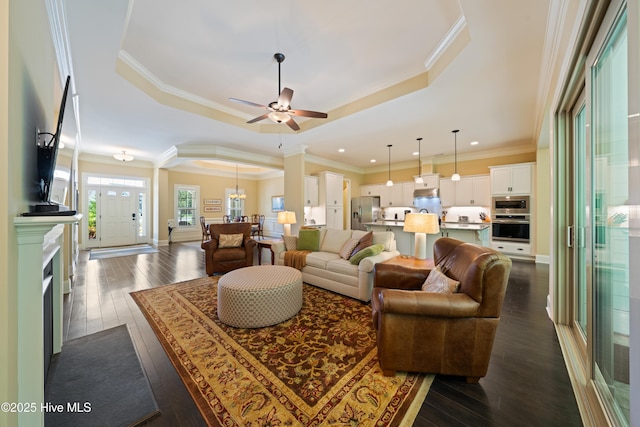 2675 Four Oak Rd, Southport, NC 28461 - living room with a raised ceiling, ceiling fan, dark wood-style floors, crown molding, and recessed lighting