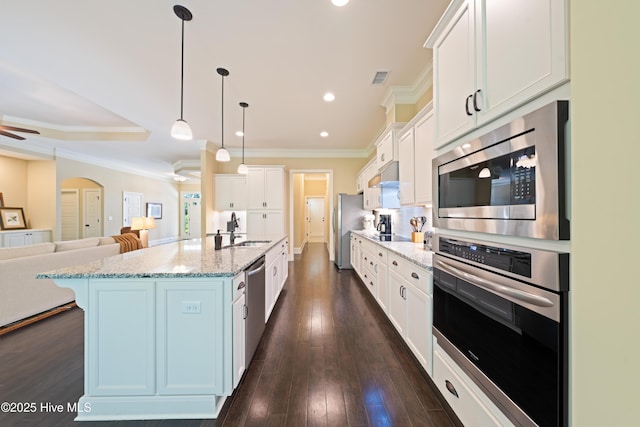 2675 Four Oak Rd, Southport, NC 28461 - kitchen featuring appliances with stainless steel finishes, white cabinets, open floor plan, crown molding, and hanging light fixtures