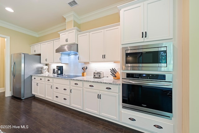 2675 Four Oak Rd, Southport, NC 28461 - kitchen with stainless steel appliances, crown molding, under cabinet range hood, white cabinets, and decorative backsplash