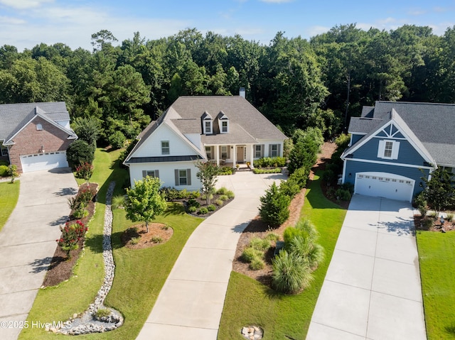2675 Four Oak Rd, Southport, NC 28461 - view of front of house featuring driveway, a front lawn, a garage, and a wooded view