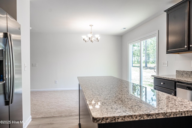 481 Peggy Mill Rd, Hamlet, NC 28345 - kitchen featuring appliances with stainless steel finishes, a chandelier, light wood-type flooring, and light stone counters