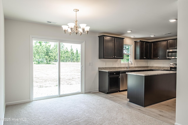 481 Peggy Mill Rd, Hamlet, NC 28345 - kitchen with stainless steel appliances, a chandelier, light stone countertops, dark brown cabinetry, and hanging light fixtures
