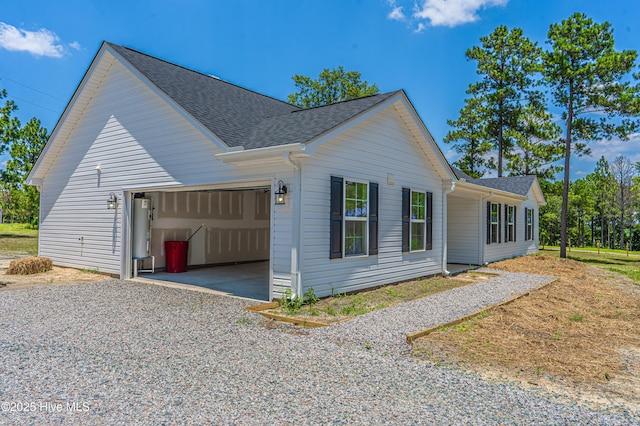 481 Peggy Mill Rd, Hamlet, NC 28345 - view of home's exterior with a garage, roof with shingles, water heater, and gravel driveway