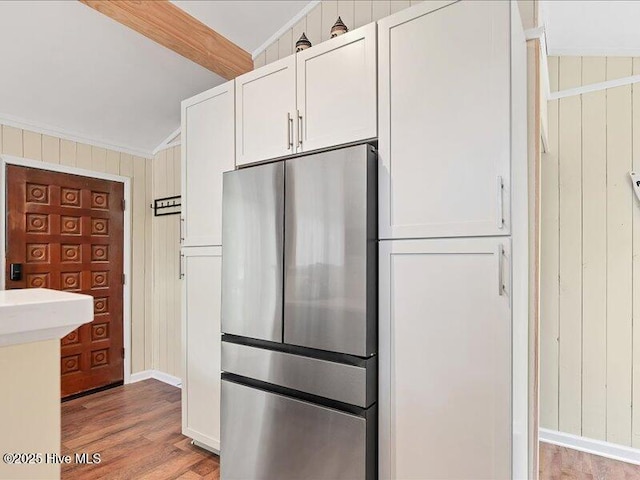 2670 Longleaf Dr SW, Pinehurst, NC 28374 - kitchen with freestanding refrigerator, light wood finished floors, white cabinets, crown molding, and wood walls