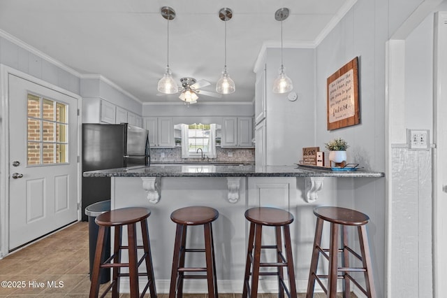 116 Waterside Dr, Bath, NC 27808 - kitchen featuring freestanding refrigerator, a peninsula, backsplash, crown molding, and ceiling fan