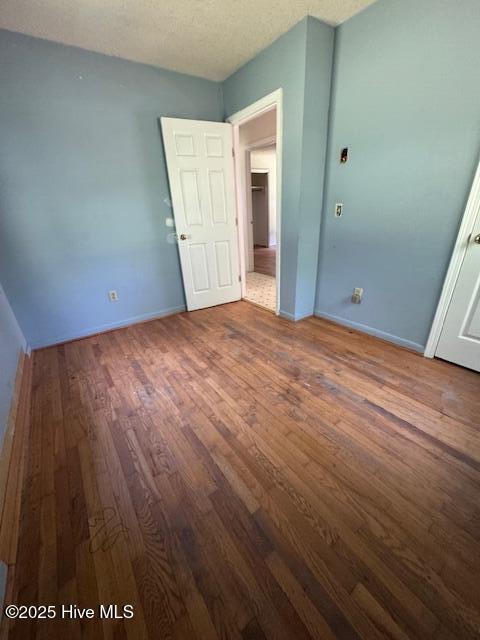 1522 Parson Grove Church Rd, Wadesboro, NC 28170 - unfurnished bedroom with wood finished floors and a textured ceiling