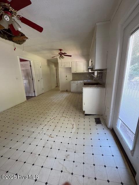 1522 Parson Grove Church Rd, Wadesboro, NC 28170 - kitchen featuring light floors, a ceiling fan, white cabinets, and wall chimney range hood