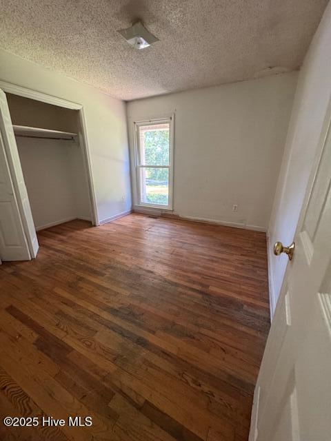 1522 Parson Grove Church Rd, Wadesboro, NC 28170 - unfurnished bedroom featuring a textured ceiling, hardwood / wood-style floors, and a closet