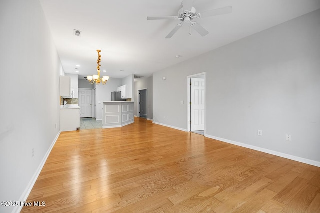 826 Shelton Ct, Wilmington, NC 28412 - unfurnished living room featuring a chandelier, light wood-style floors, and a ceiling fan