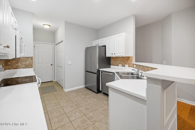 826 Shelton Ct, Wilmington, NC 28412 - kitchen featuring appliances with stainless steel finishes, a peninsula, backsplash, white cabinets, and light countertops