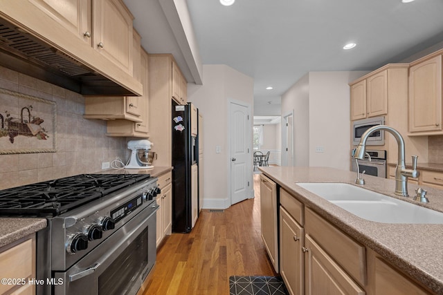 106 Blue Heron Cir, Sneads Ferry, NC 28460 - kitchen with stainless steel appliances, under cabinet range hood, light brown cabinetry, tasteful backsplash, and recessed lighting