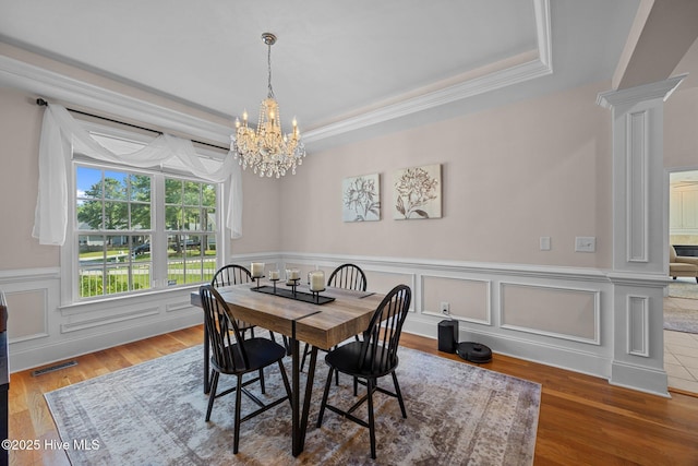 106 Blue Heron Cir, Sneads Ferry, NC 28460 - dining space with a chandelier, a tray ceiling, a wainscoted wall, wood finished floors, and ornamental molding
