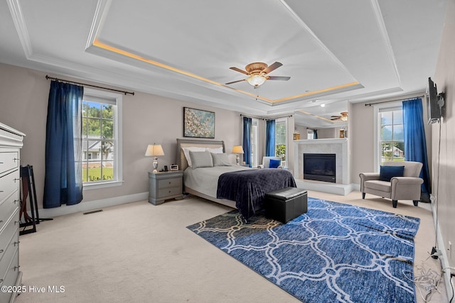 106 Blue Heron Cir, Sneads Ferry, NC 28460 - bedroom with a raised ceiling, carpet floors, a glass covered fireplace, and crown molding