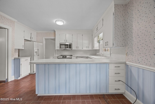 1902 York St, Kinston, NC 28504 - kitchen featuring wallpapered walls, stainless steel appliances, crown molding, a peninsula, and light countertops