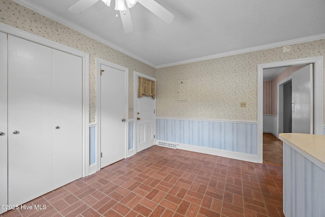 1902 York St, Kinston, NC 28504 - unfurnished bedroom with ornamental molding, brick patterned floors, a closet, wallpapered walls, and a ceiling fan