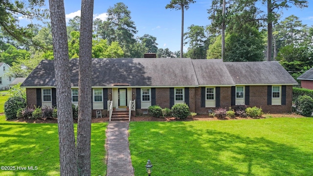 1902 York St, Kinston, NC 28504 - view of front of home featuring brick siding, a front lawn, roof with shingles, and a chimney
