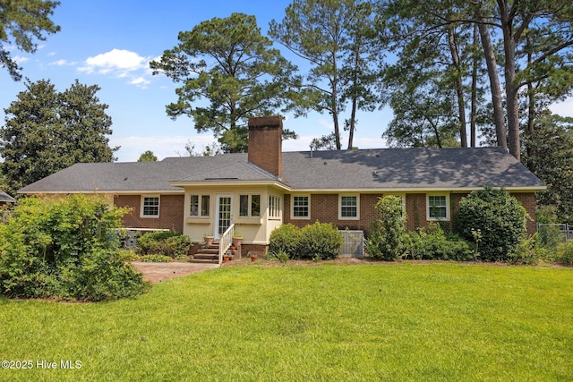 1902 York St, Kinston, NC 28504 - view of front facade featuring brick siding, a chimney, a front yard, and entry steps