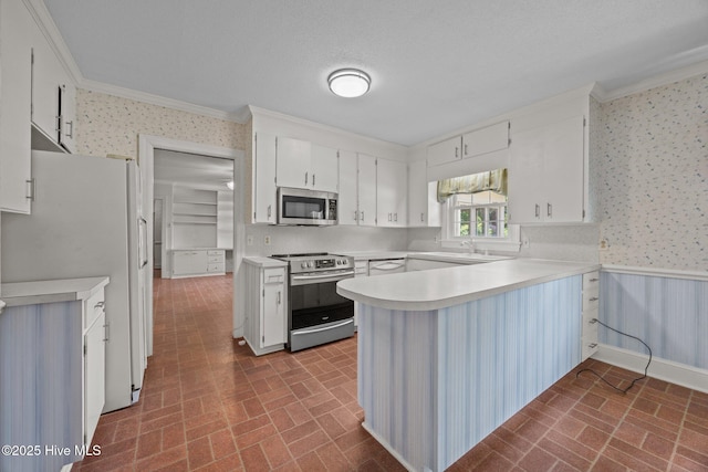 1902 York St, Kinston, NC 28504 - kitchen featuring appliances with stainless steel finishes, wallpapered walls, brick patterned flooring, crown molding, and a peninsula