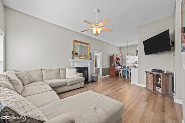 2824 Preston Ln, Grimesland, NC 27837 - living room featuring light wood-style flooring, a ceiling fan, a fireplace with flush hearth, and vaulted ceiling
