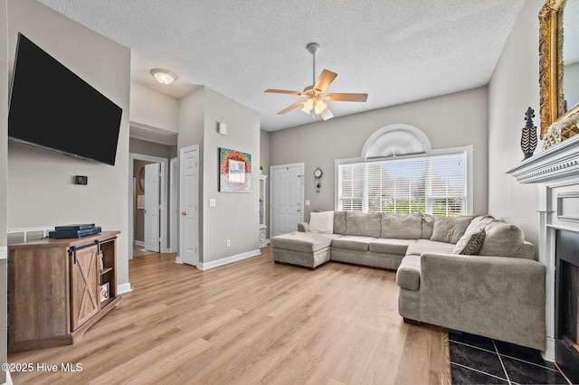 2824 Preston Ln, Grimesland, NC 27837 - living area featuring a ceiling fan, light wood-style flooring, a fireplace, and a textured ceiling