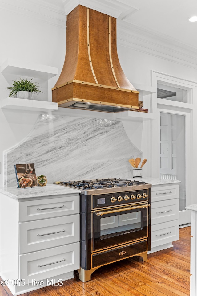 503 S 3rd St, Wilmington, NC 28401 - kitchen with range with two ovens, premium range hood, crown molding, open shelves, and white cabinetry